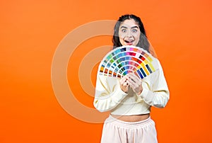 Beautiful surprised woman with color palette fun. Paint and painting concept.
