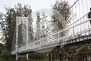 Beautiful suspension bridge in city park under sunset light at U