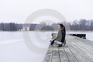 Beautiful Swedish caucasian fitness teen girl sitting on wood bridge outdoor in winter landscape