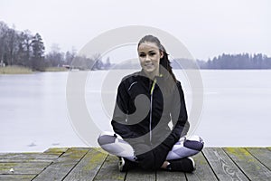 Beautiful Swedish caucasian fitness teen girl sitting on wood bridge outdoor in winter landscape