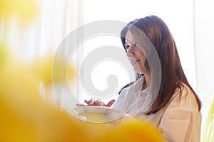 Beautiful sweet girl in nightgown in early morning with bouquet of delicate yellow tulips. Gift on International