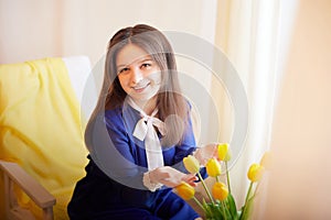 Beautiful sweet manager girl in romantic business dress with fresh flowers in office. A young businesswoman on