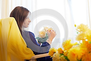 Beautiful sweet manager girl in romantic business dress with fresh flowers in office. A young businesswoman on