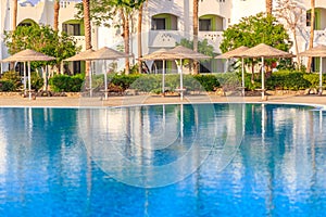 Beautiful swimming pool, the luxury hotel and palm trees