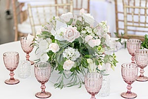 Beautiful table setting with crockery and flowers for a party, wedding reception or other festive event. Glassware and