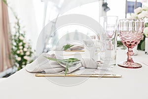 Beautiful table setting with crockery and flowers for a party, wedding reception or other festive event. Glassware and