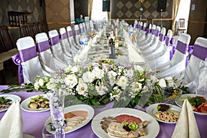 Beautiful table setting with crockery and flowers for a party, wedding reception or other festive event. Glassware and cutlery for