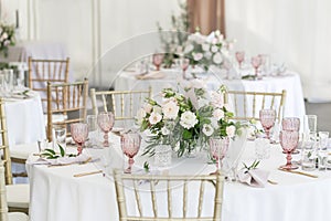 Beautiful table setting with crockery and flowers for a party, wedding reception or other festive event. Glassware and