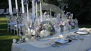 Beautiful table setting with crockery and flowers for a party, wedding reception or other festive event. On the shores