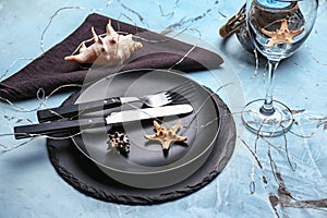 Beautiful table setting with sea shells on light background