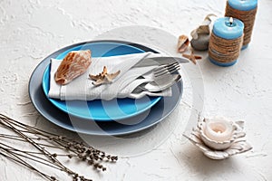 Beautiful table setting with sea shells on light background