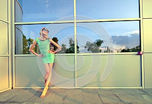 Beautiful tall fashion model posing in front of modern building