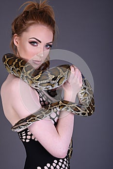 Beautiful, Tall, Slim, Busty Redhead Model in a sexy, black, mesh Dress, posing with a Snake