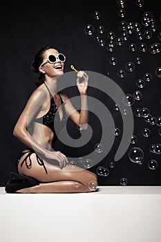 Beautiful Tan Female Model Posing In Bikini And Blow Bubbles