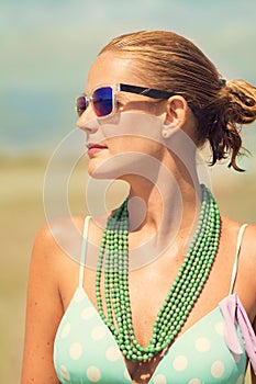 Beautiful tanned blond woman on the beach sunbathing