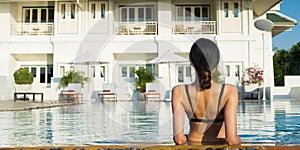 Woman along big blue swimming pool and nice sky ho