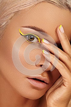 Beautiful tanned skin woman. Sunburnt girl face with natural bronzed make-up, yellow manicure. Sexy summer style makeup