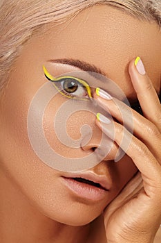 Beautiful tanned skin woman. Sunburnt girl face with natural bronzed make-up, yellow manicure. Sexy summer style makeup photo