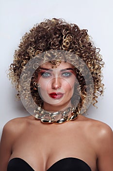 Beautiful tanned woman with curly afro hair and fancy disco makeup