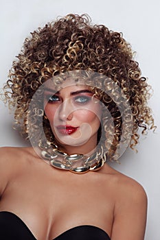 Beautiful tanned woman with curly afro hair and fancy disco makeup