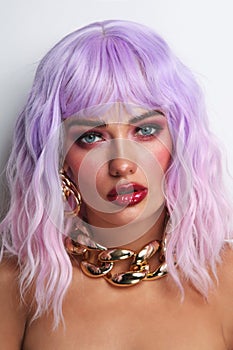 Beautiful tanned woman with lilac hair and bright fancy makeup