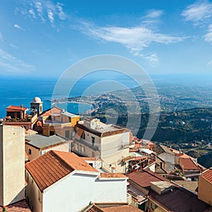 Beautiful Taormina sea coast panoramic view from Castelmola mountain village and Castelmola roofs, Sicily, Italy. People