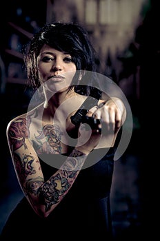 Beautiful tattooed girl with attitude holding guns