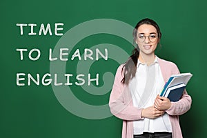 Teacher near green chalkboard with text Time To Learn English