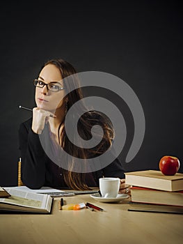 Beautiful teacher sitting at her desk