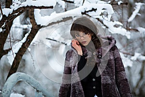 Beautiful teacher, student with glasses, fur coat in winter forest