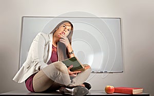 Beautiful teacher thinking on desk