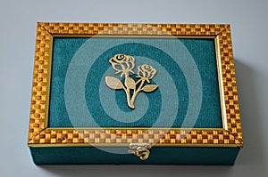 Beautiful teal and golden coloured dry fruit box with white background beautifully designed box. Gift box with goodies.