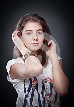 Beautiful teen girl with brown straight hair, posing on background