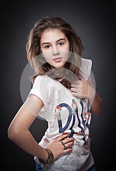 Beautiful teen girl with brown straight hair, posing on background photo
