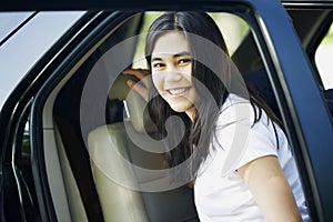 Beautiful teen girl by car door