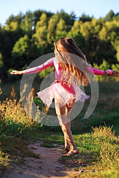 Beautiful teen girl Is dancing outside at summer sunset