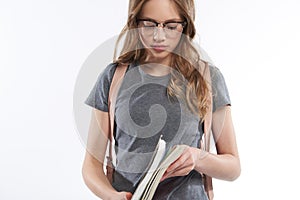Beautiful teen girl in glasses opening her notebook