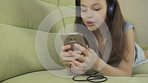 Beautiful teen girl in headphones singing karaoke songs in smartphone stock footage video