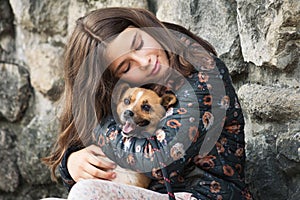 Beautiful teen girl hugging her new pet adopted friend  dog from rescue shelter