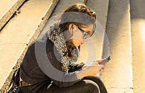 Beautiful teen girl looking at her smartphone - warm filter