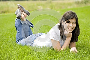 Beautiful teen girl lying on grass