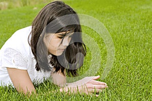 Beautiful teen girl lying on grass