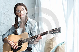 beautiful teen girl playing acoustic guitar photo
