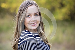 Beautiful teen girl portrait outdoors. Smiling and looking at the camera