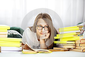 Beautiful teen girl reading a book in the room. Concept of education, hobby, study and world book day