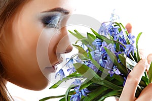 Beautiful teen girl smell and enjoy fragrance of snowdrop flower photo