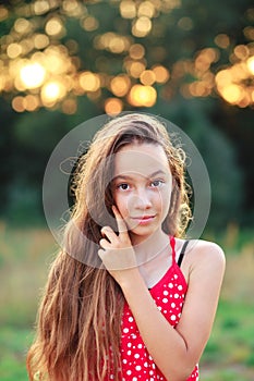 Beautiful Teen Girl is smiling and  enjoying nature in the park at Summer sunset