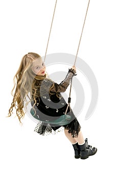 Beautiful teen school girl swinging on a swing. Concept summer vacation.