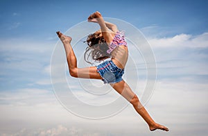 Beautiful teenage girl dancing and jumping on the beach