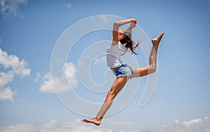 Beautiful teenage girl dancing and jumping on the beach